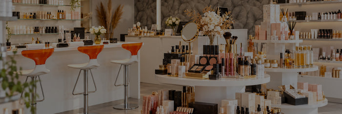 Ambiance de la boutique Cosmesud à Baillargues : présentoirs de cosmétiques, rayons blancs et Beauty Bar aux tabourets orange
